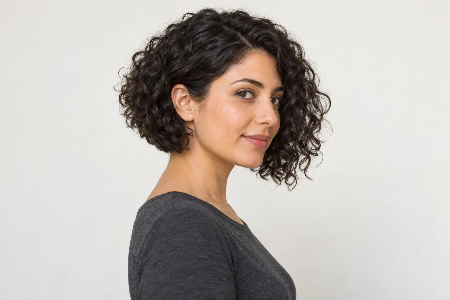 Softly angled curly bob with longer front pieces and a shorter back