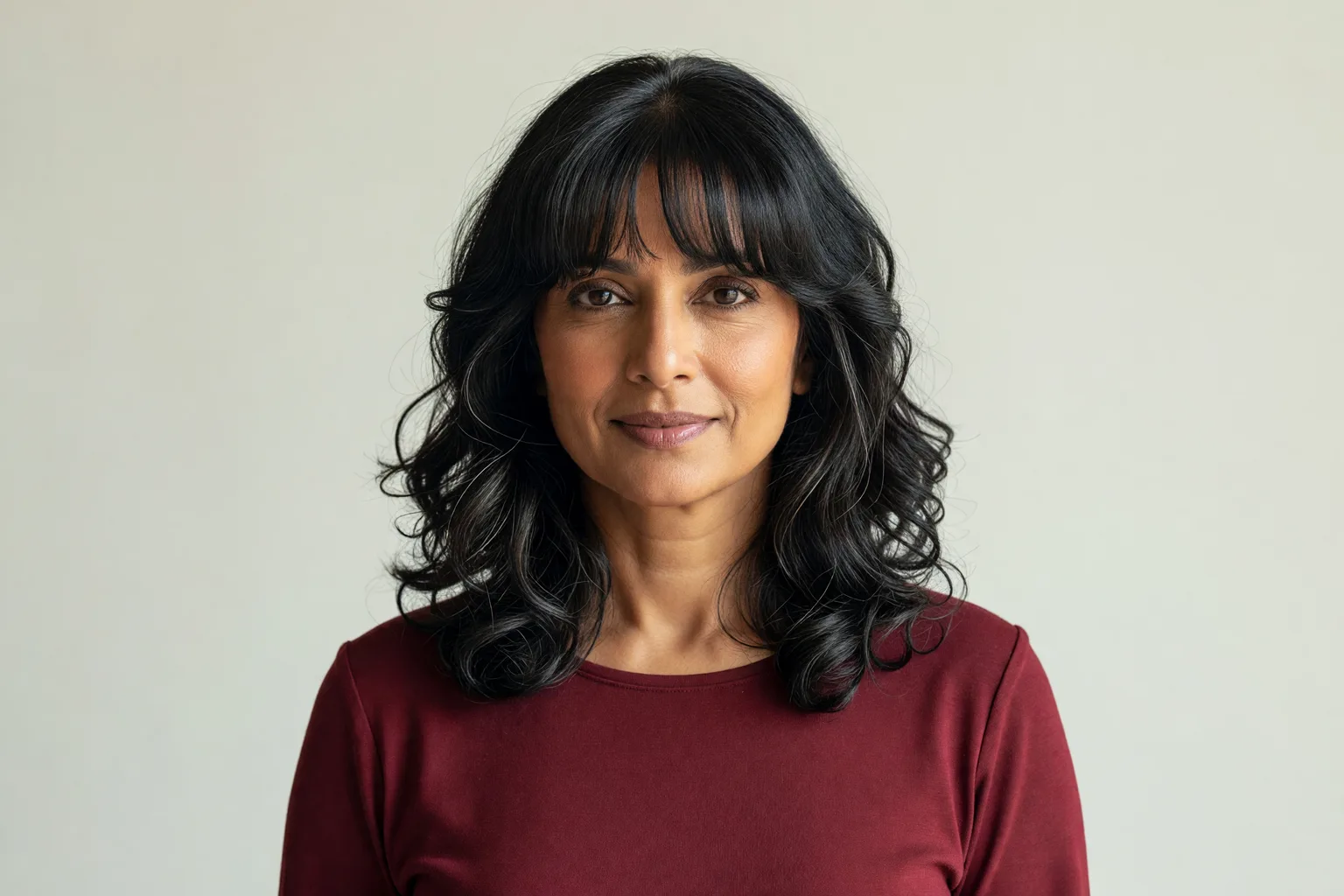 Generated portrait of a woman in her mid 50s with grown-out curtain bangs at chin length blended into face-framing layers