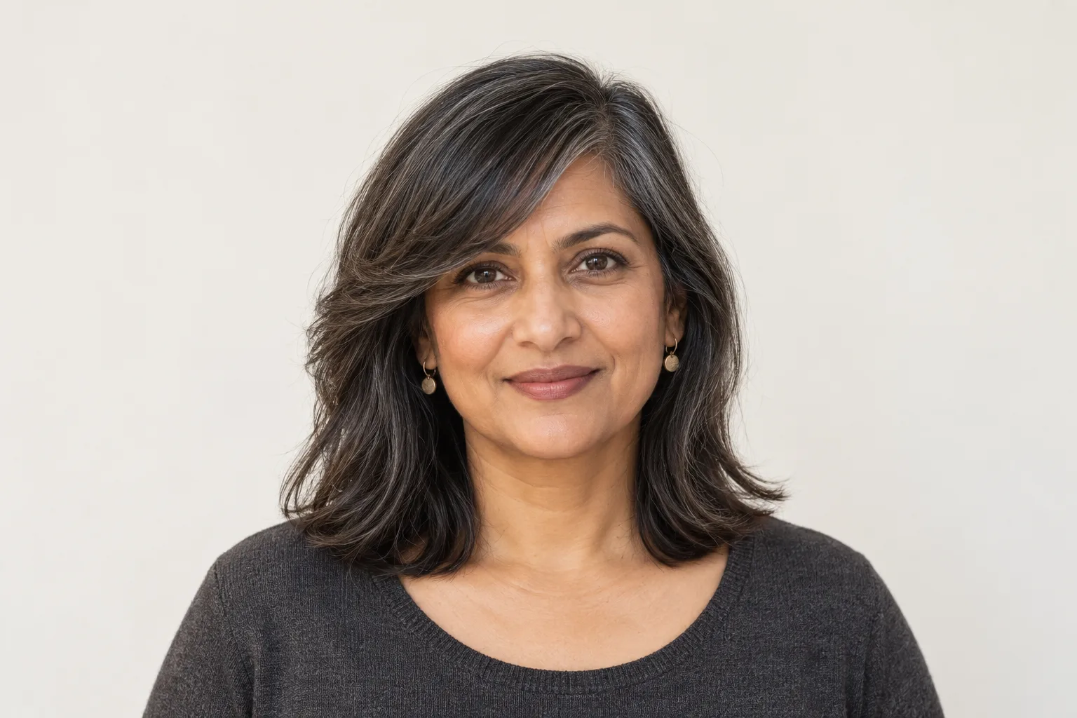 Generated soft side-swept fringe ending beside the outer eye above shoulder-length hair