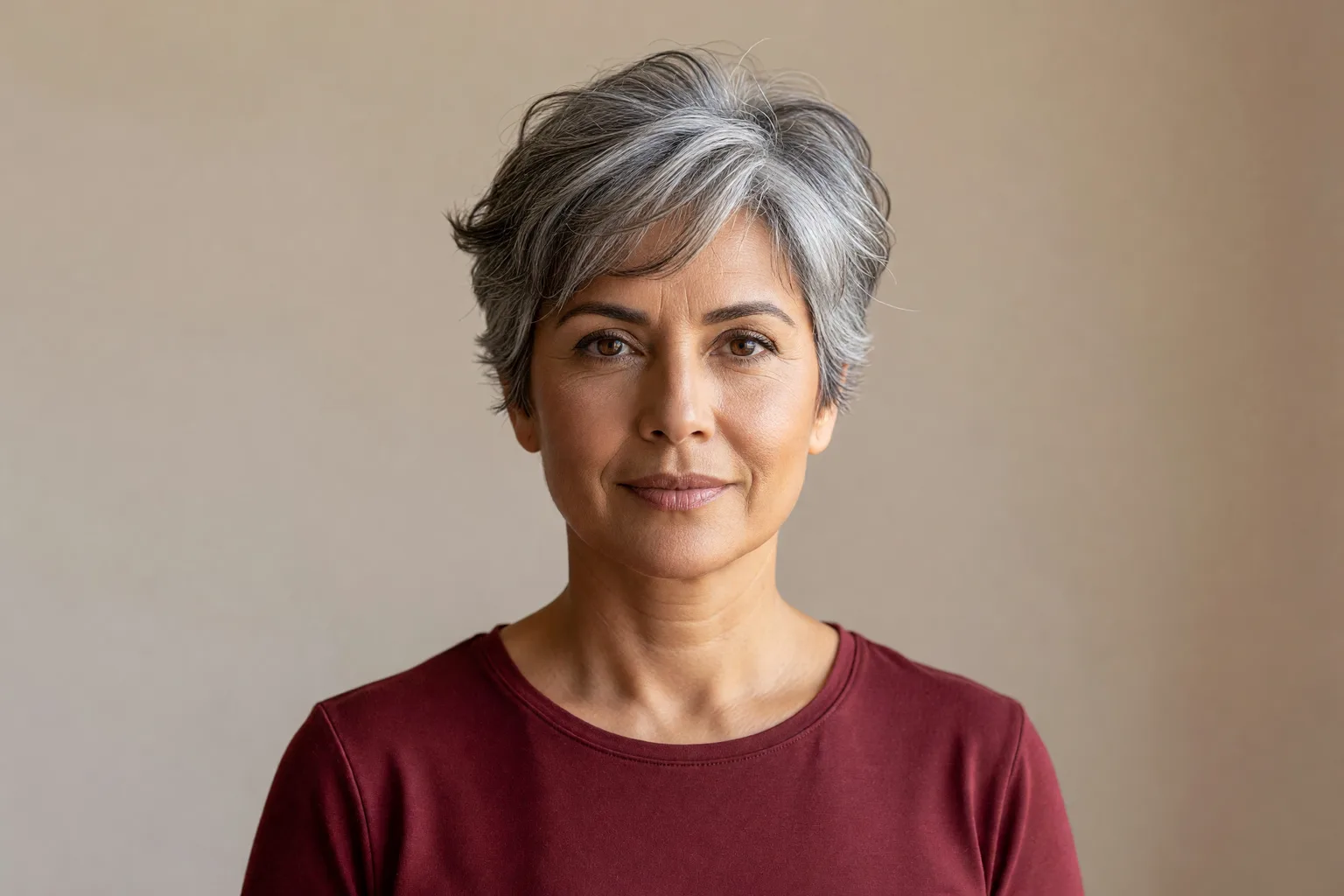 Woman around 58 with a soft textured pixie cut in salt-and-pepper hair